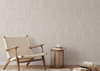 Abstract line wallpaper in a living room with a woven lounge chair and wooden side table.