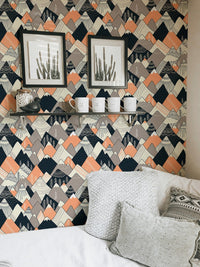 Grey and orange geometric wallpaper in a living area with framed art.
