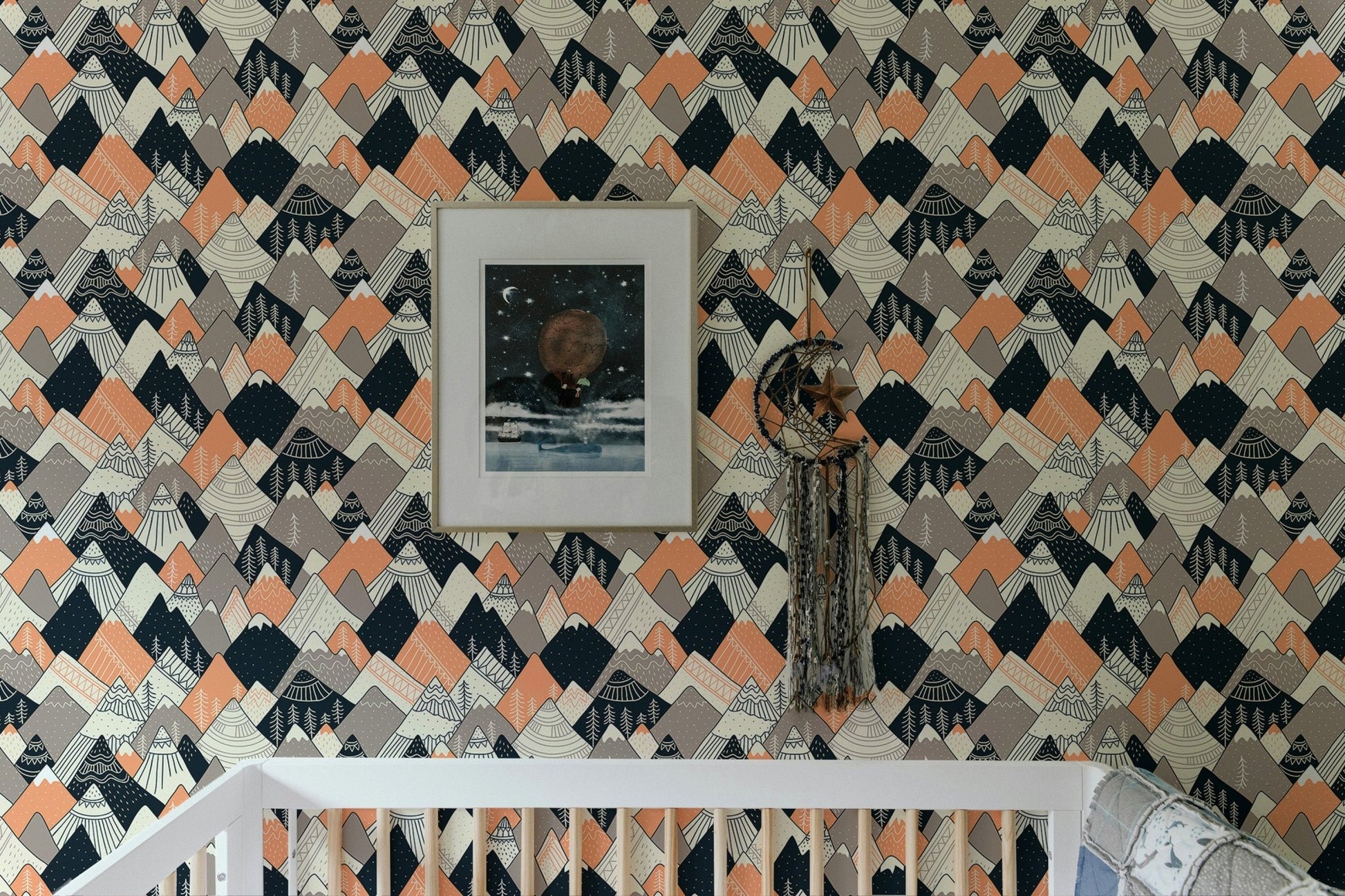 Geometric mountain pattern wallpaper in a nursery with a white crib.