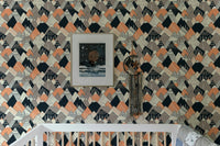 Geometric mountain pattern wallpaper in a nursery with a white crib.