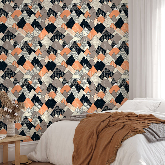 Scandinavian peak wallpaper behind a bed with terracotta linens.