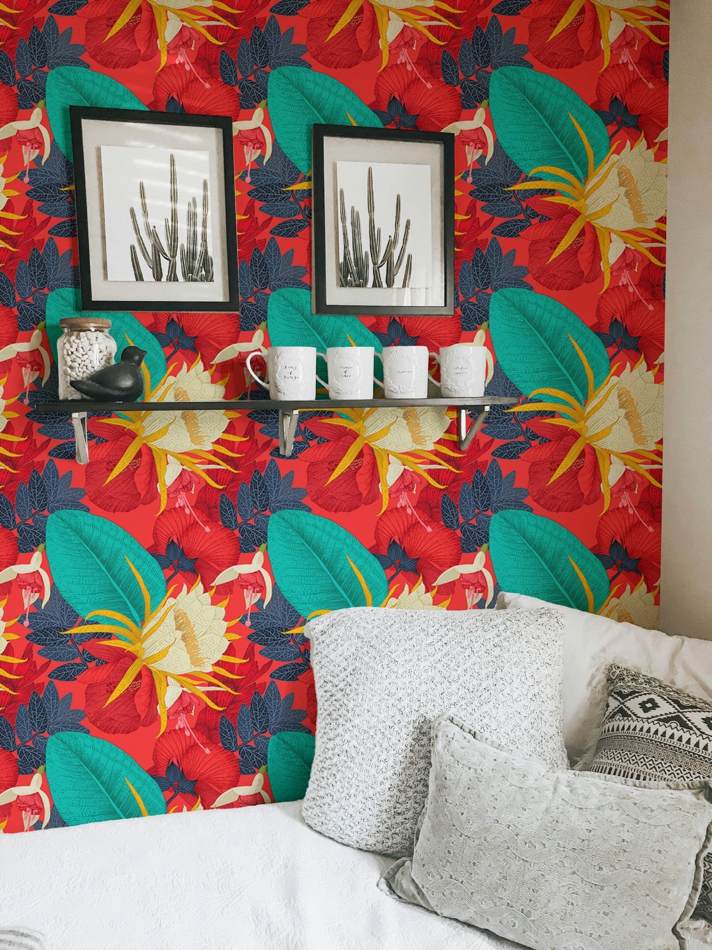 Tropical floral wallpaper behind white pillows and black wall frames.