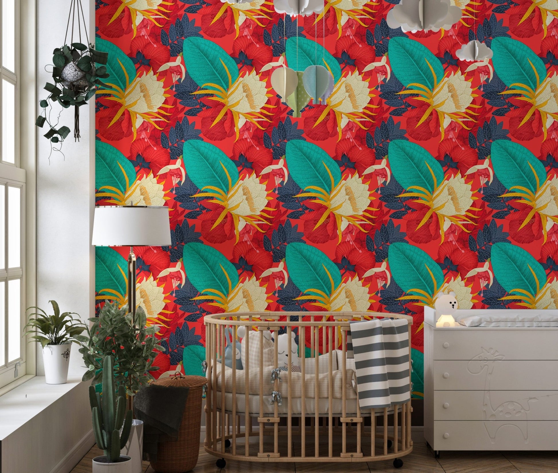 Tropical floral wallpaper in a nursery with a wooden crib and white lamp.