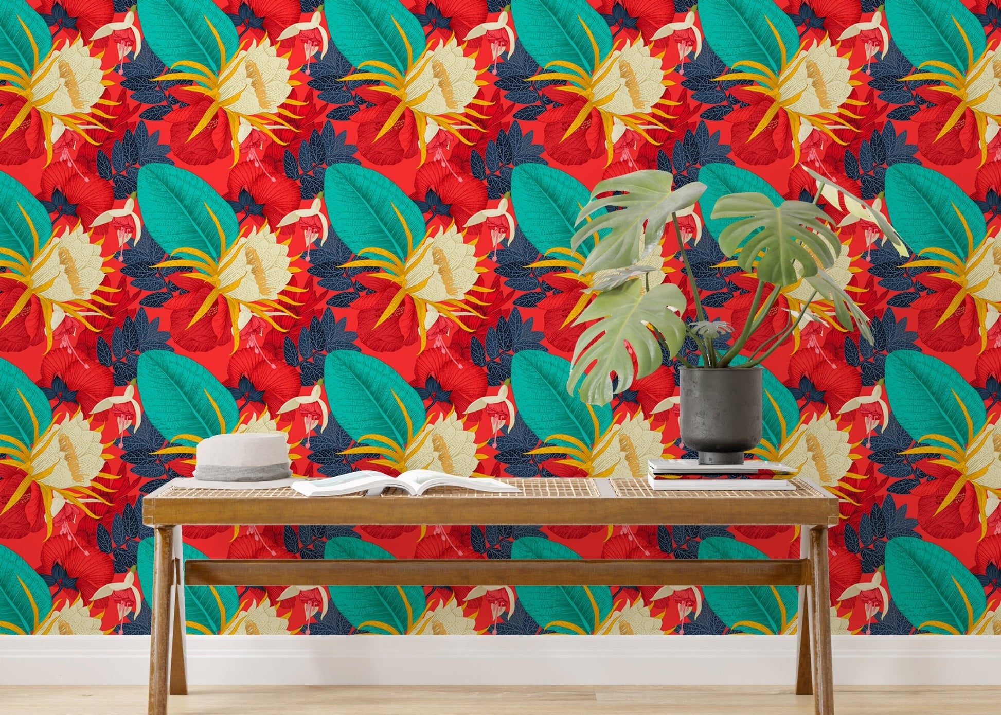 Floral wallpaper with teal leaves behind a wooden bench and green plant.