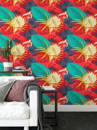 Red tropical wallpaper behind a sofa with pink and white cushions.