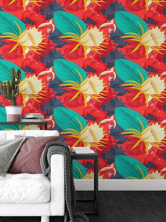 Red tropical wallpaper behind a sofa with pink and white cushions.
