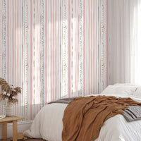 Bedroom featuring pink striped wallpaper and a bed with orange bedding.