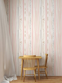 Minimalist dining area with a wooden table and pink vertical line wallpaper.
