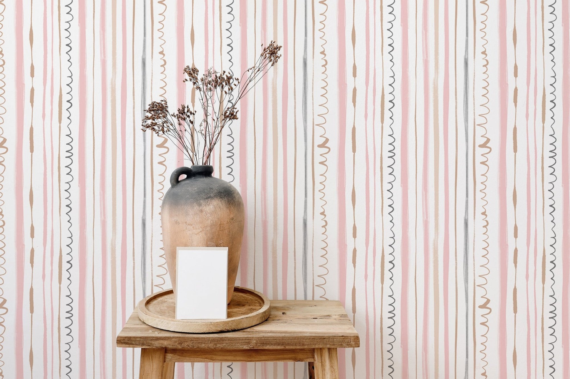 Seamless Pattern Vertical Lines Pink Wallpaper behind a vase on a wooden stool.
