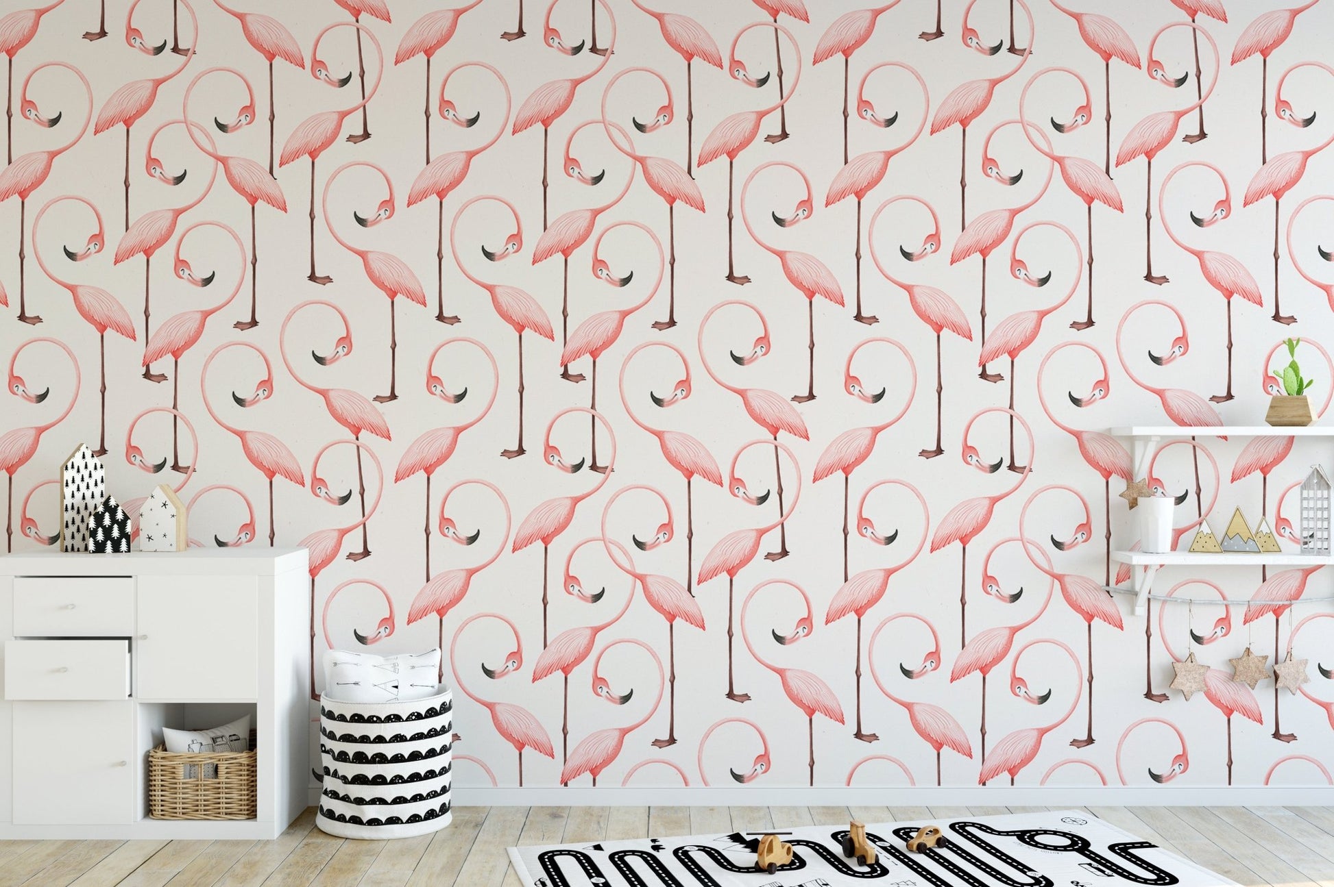 Minimalist nursery area with pink flamingo wallpaper and wooden desk.