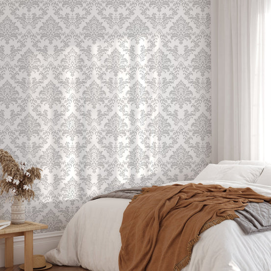 Gray and white wallpaper in a bright bedroom with a brown throw blanket.