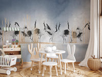 Crane wall mural in a playroom with a small white table and chairs.