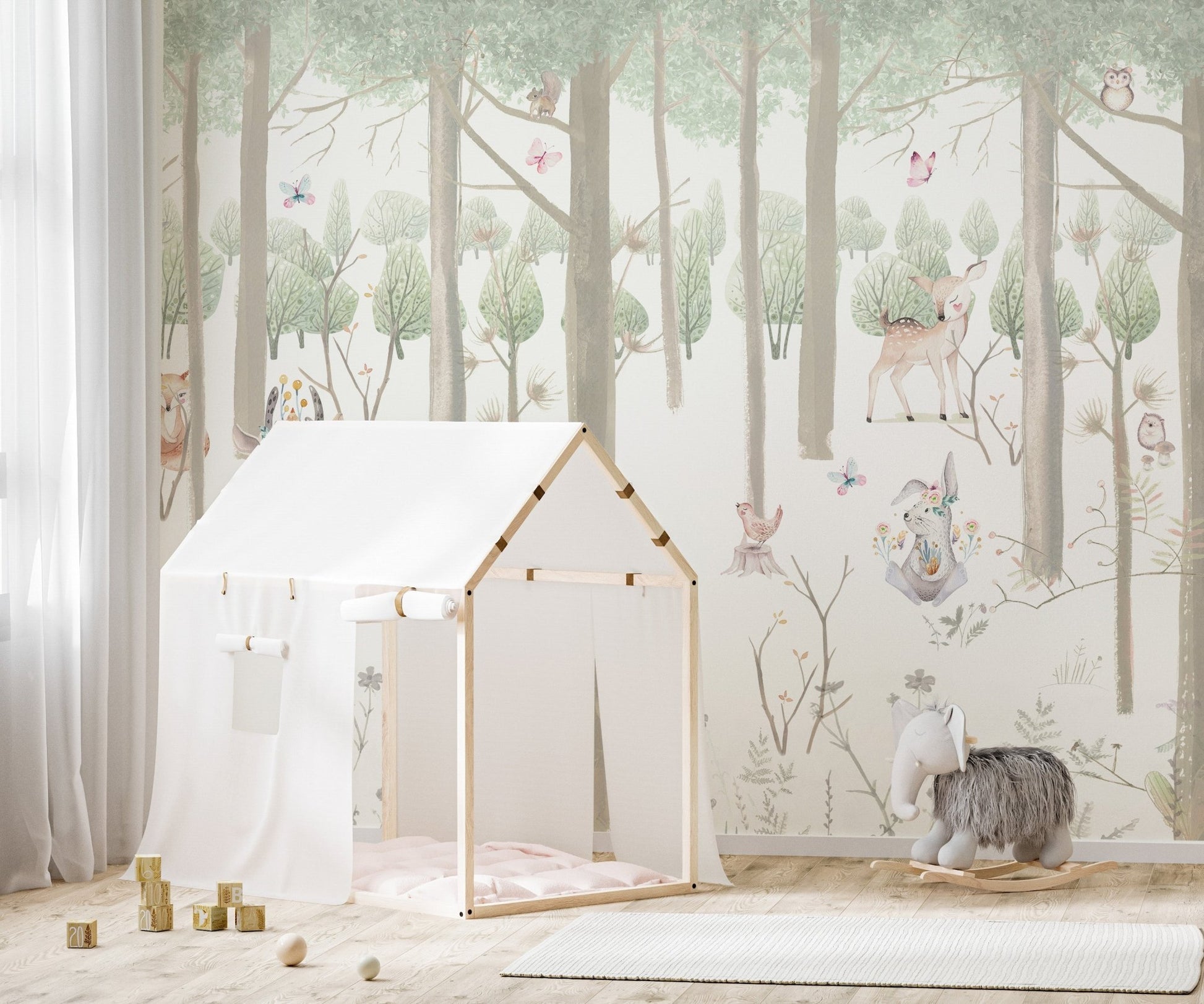 Light green forest theme wall mural in a child's room.