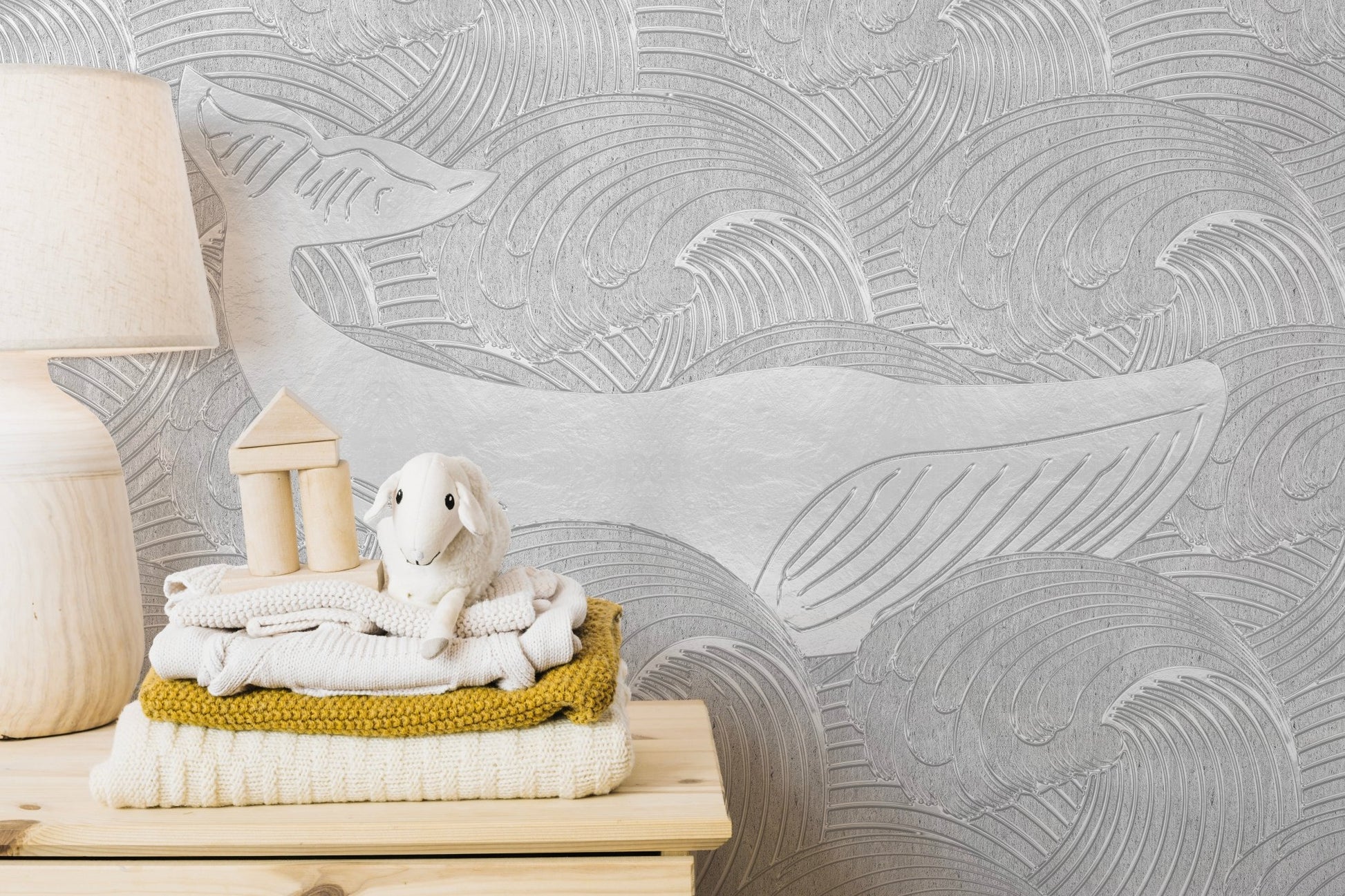 Silver Whale Handmade Wall Mural on a bedroom wall with folded linens.