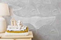 Silver Whale Handmade Wall Mural on a bedroom wall with folded linens.