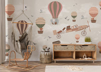 Hot air balloon safari wall mural in a nursery with a wooden rocking chair.