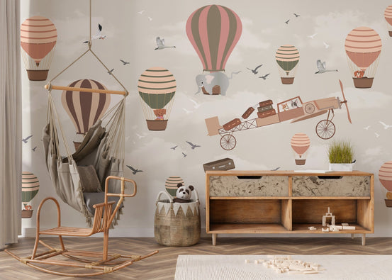 Hot air balloon safari wall mural in a nursery with a wooden rocking chair.