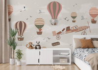 Vibrant bedroom mural featuring wildlife in a whimsical sky safari scene behind bed.
