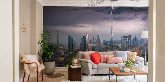 Skyscrapers wall mural for a living room with a grey sofa and indoor plants.