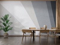 Geometric grey concrete wall mural behind a modern dining table and chairs.
