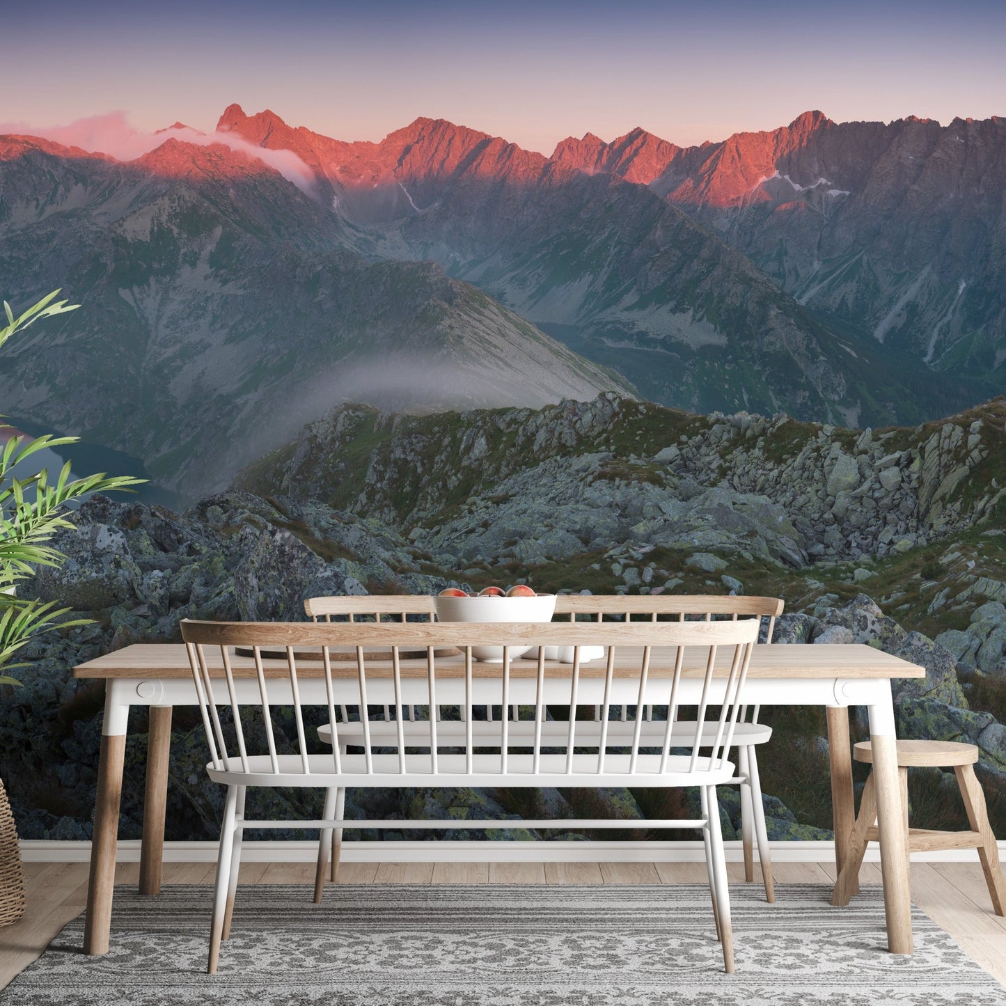 Mountain range wall mural in a dining area with wooden table and bench.