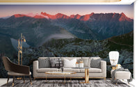 Grey and orange mountain wall mural in a living area with marble coffee table.
