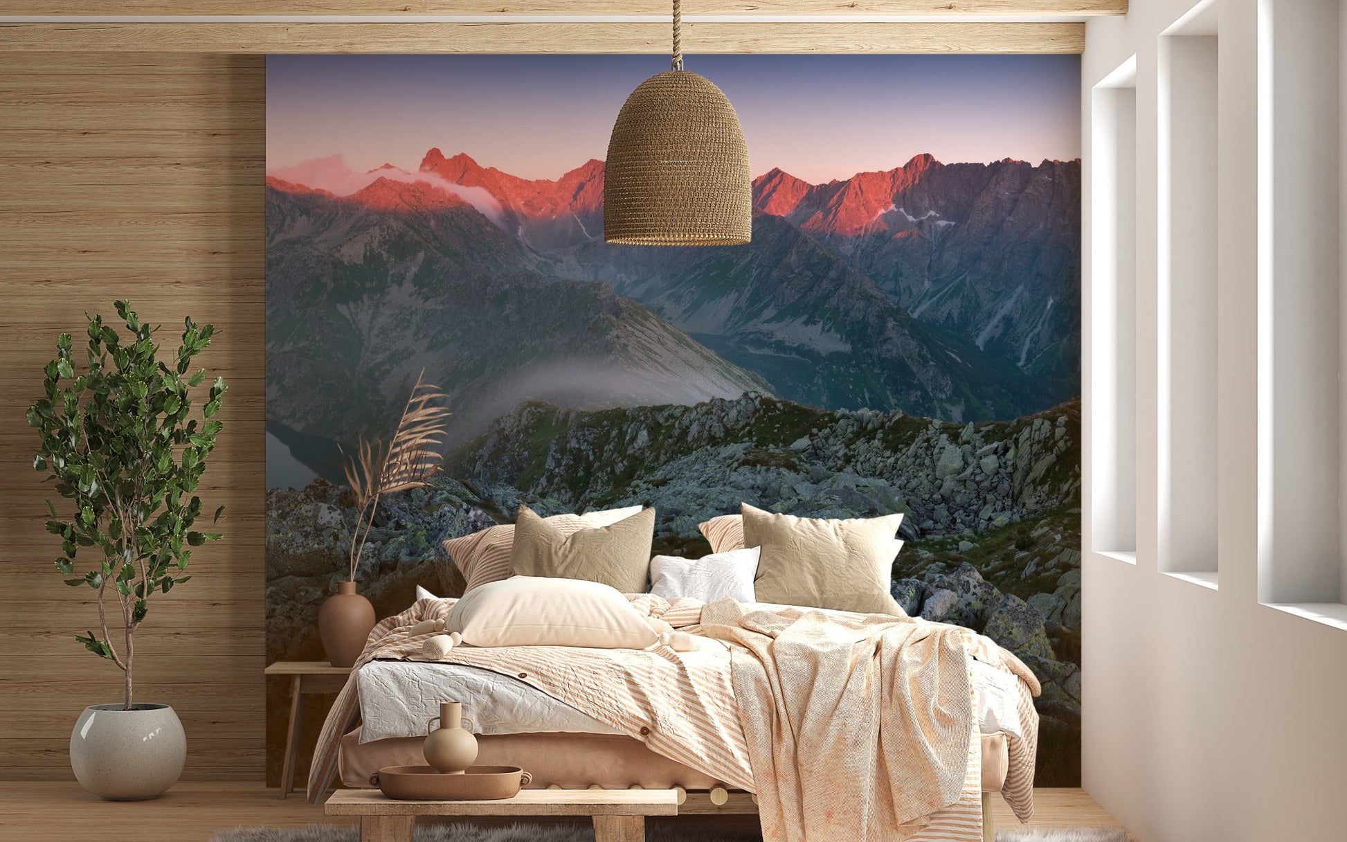 Sunset mountain mural behind a wooden bed frame and pendant light