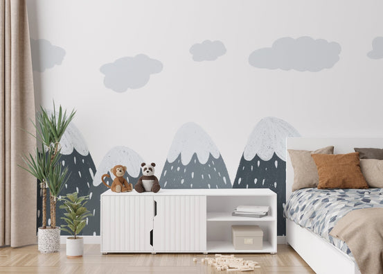 Minimalist mountain wall mural behind a white sideboard and indoor green plants.