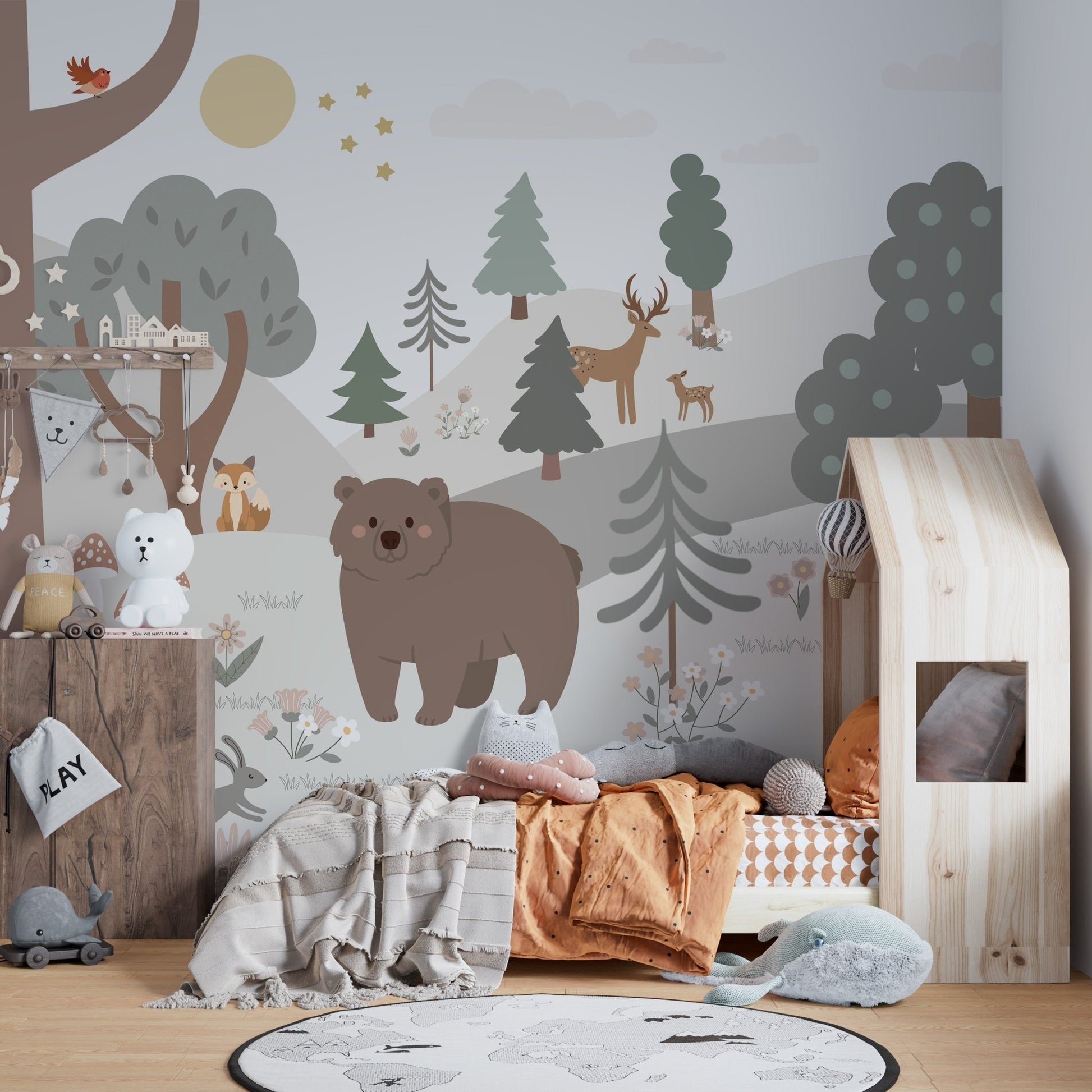 Grey and brown forest wall mural in a nursery with a wooden house bed.