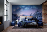 Night sky mountain wall mural in a dark bedroom with navy blue bedding.