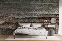 Minimalist bedroom with weathered brick wall mural and simple decor.