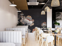 Restaurant booth seating with dark gray floral wall mural and modern pendant lighting.