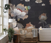 Nursery wall mural showing large flowers behind a wooden crib and white dresser.