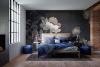 Bedroom wall mural with dark flower graphics behind a blue bed and large windows.