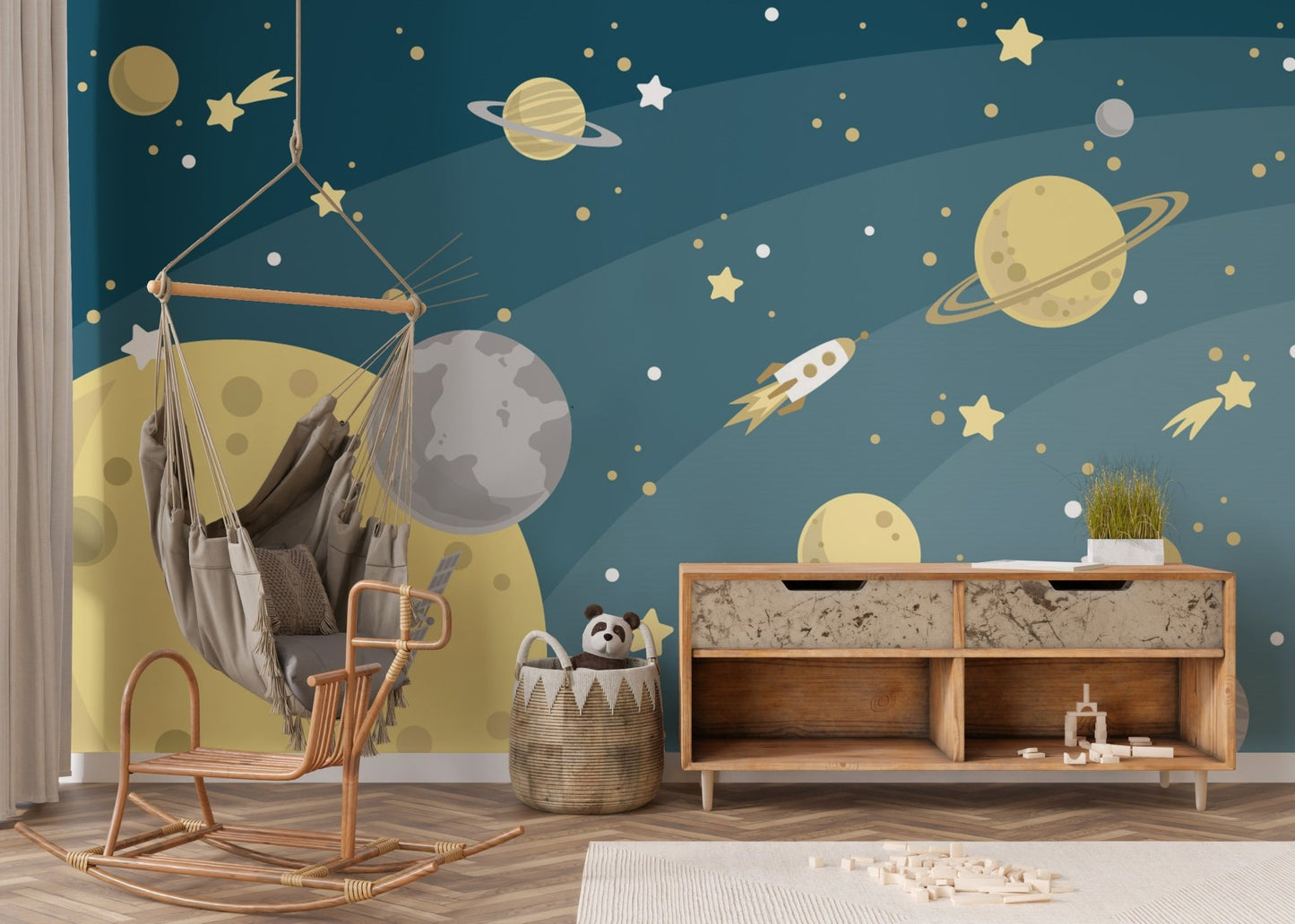 Play area featuring a celestial planets wall mural with moon and star patterns on a dark blue base.