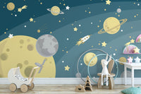 Navy blue galaxy wall mural featuring yellow planets and rockets in a children's bedroom.