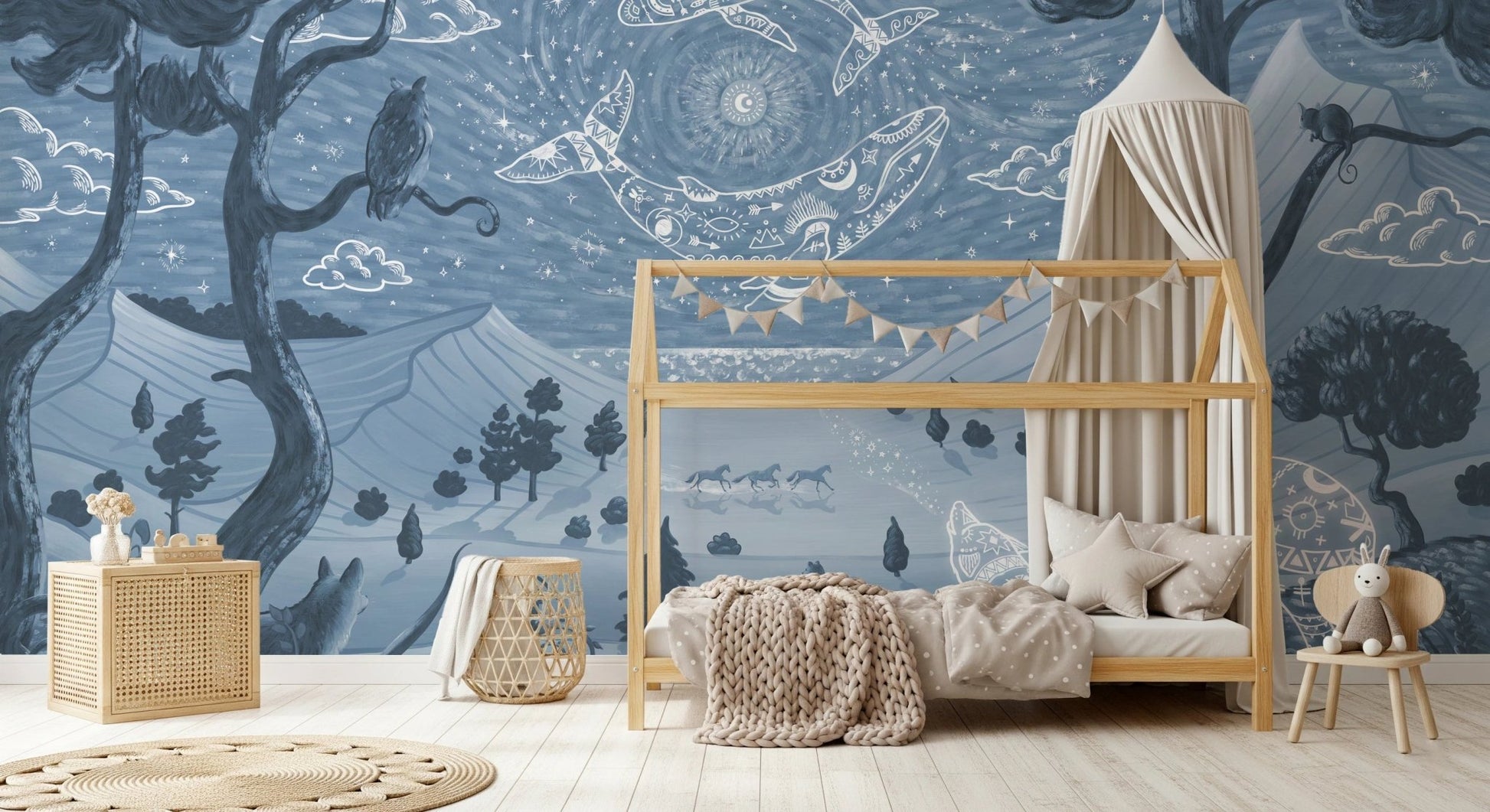 Toddler room with a house-shaped bed frame and blue forest wall mural.