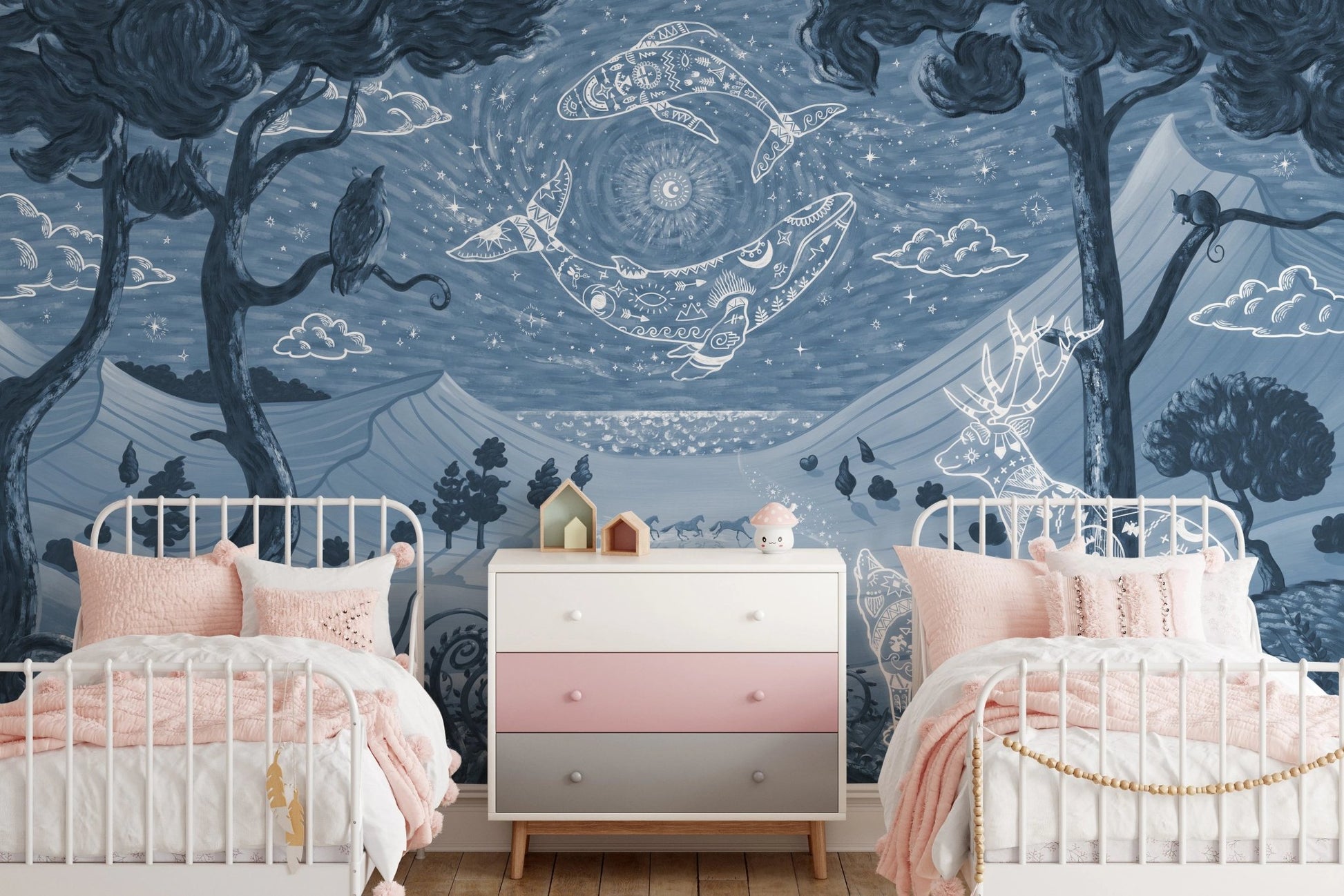 Twin beds in a shared room with blue forest pattern wall mural and pink accents.