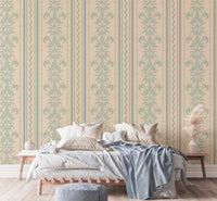 Sage green and beige damask wallpaper in a master bedroom with neutral linens.
