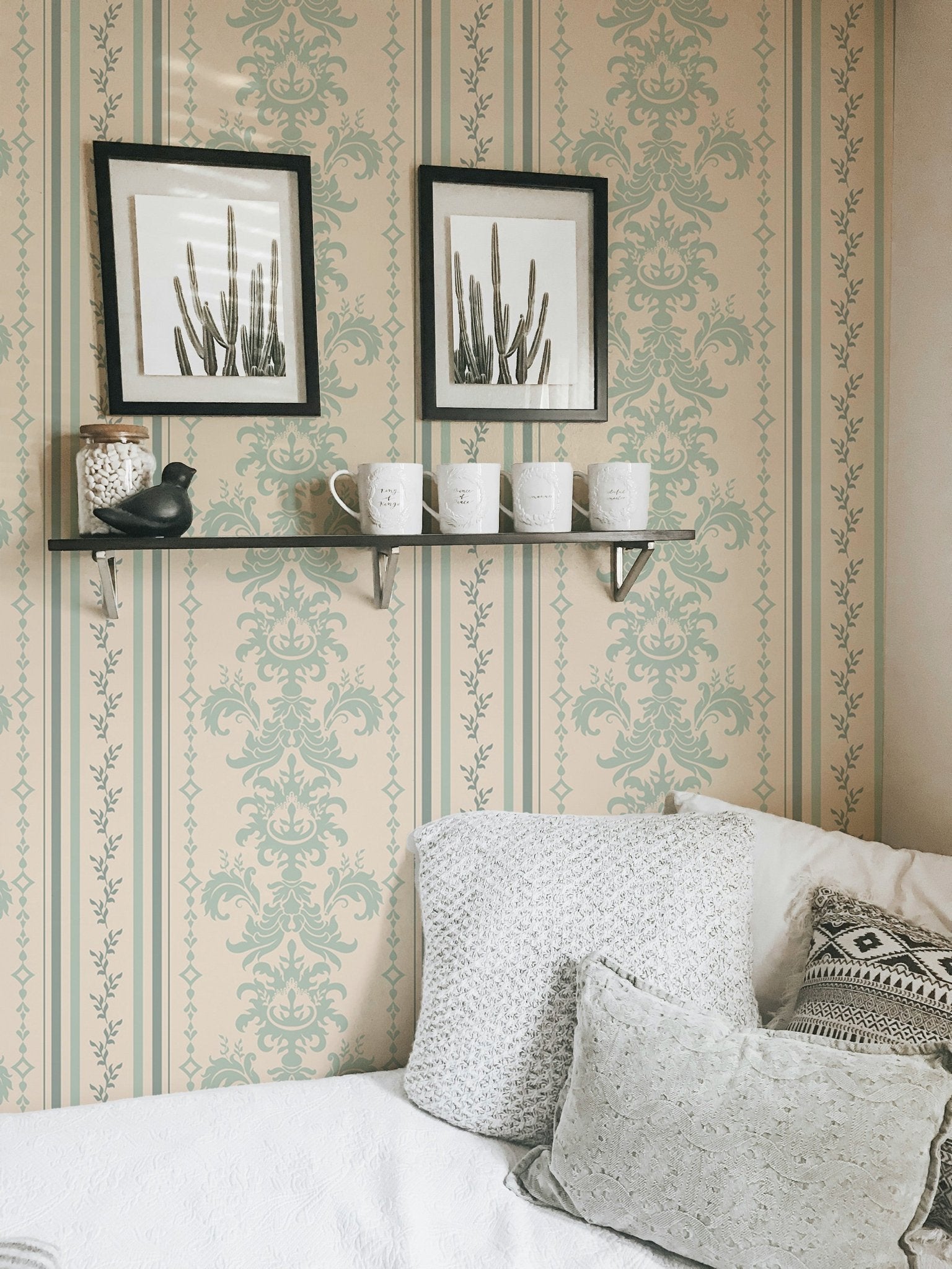 Striped damask wallpaper with black framed art and a white sofa.