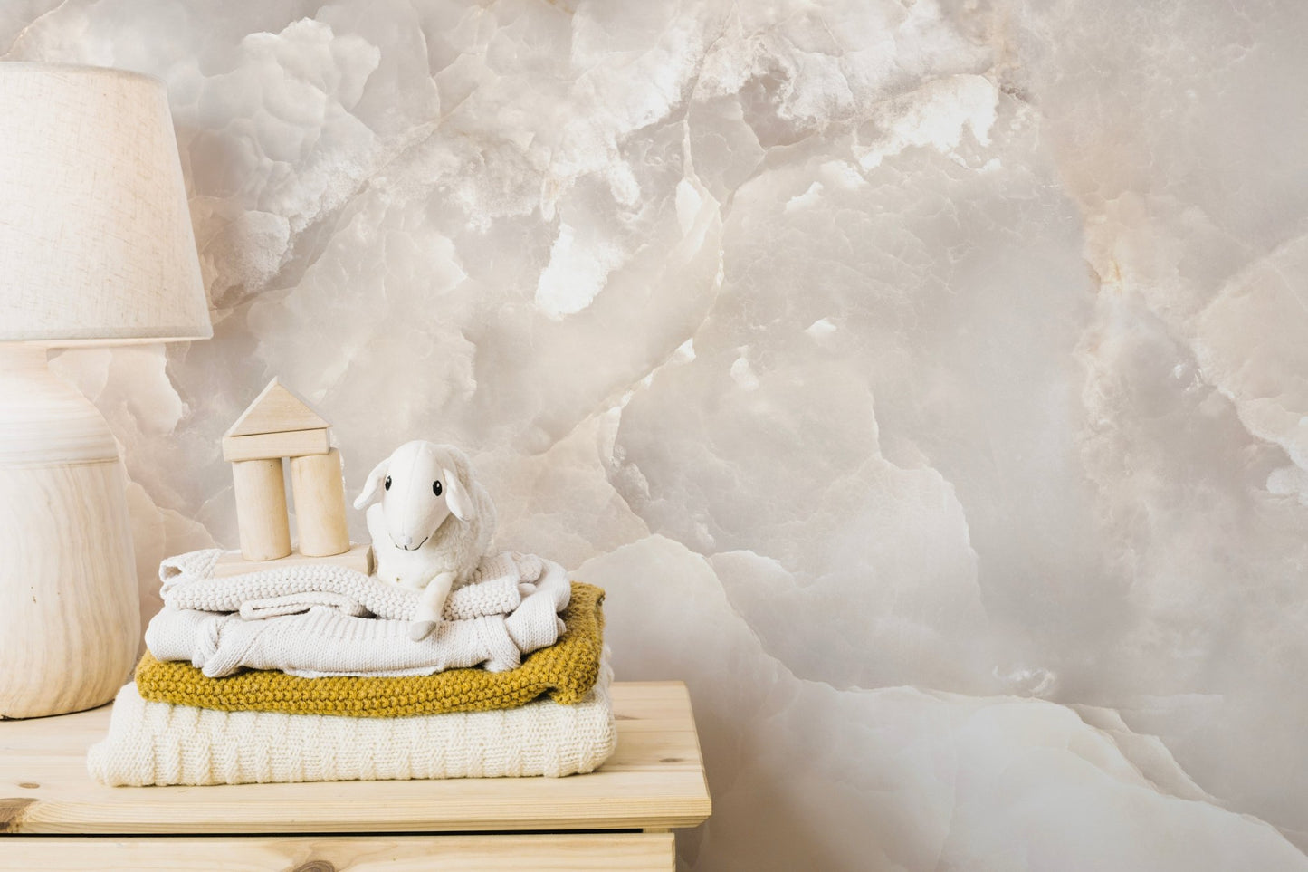 Stone texture wall mural displayed behind a wooden shelf with towels.
