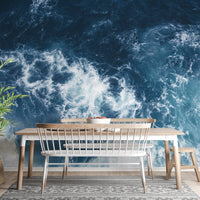 Dining room with white chairs and a teal oceanic glacier wall mural.