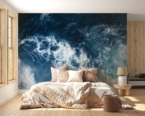 Bedroom with beige linens against a navy blue Stormy Sea Glacier Wall Mural.