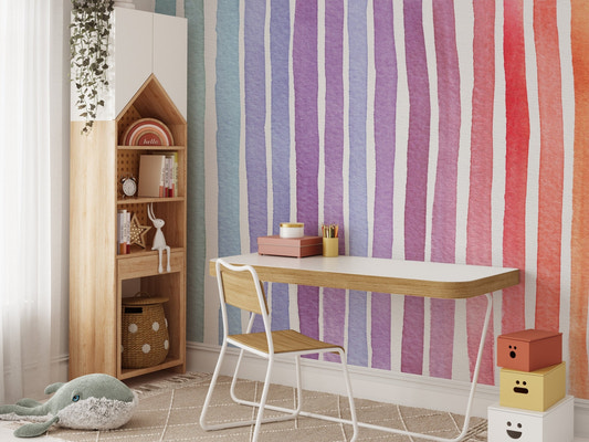 Colorful vertical stripe wallpaper behind a wooden desk and chair set.