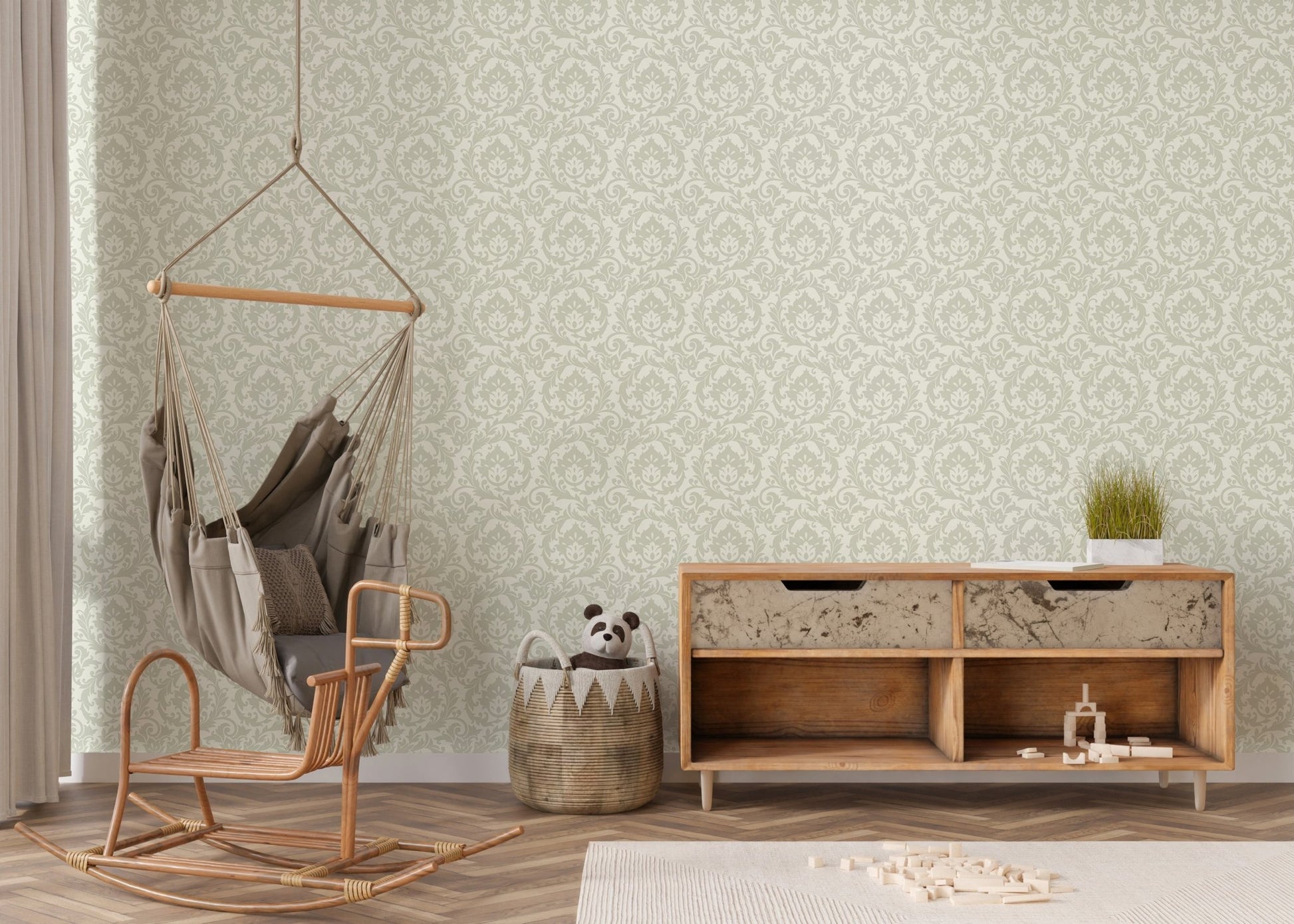 Light green autumn leaf wallpaper behind wicker hanging chair and console