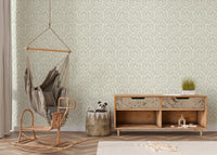 Light green autumn leaf wallpaper behind wicker hanging chair and console