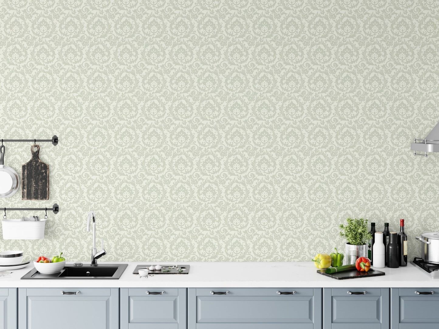 Pale green leaves motif wallpaper in kitchen above white countertop and sink