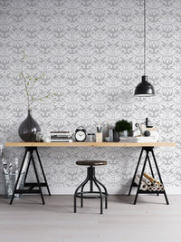 Industrial style home office with a damask wallpaper and black metal desk.
