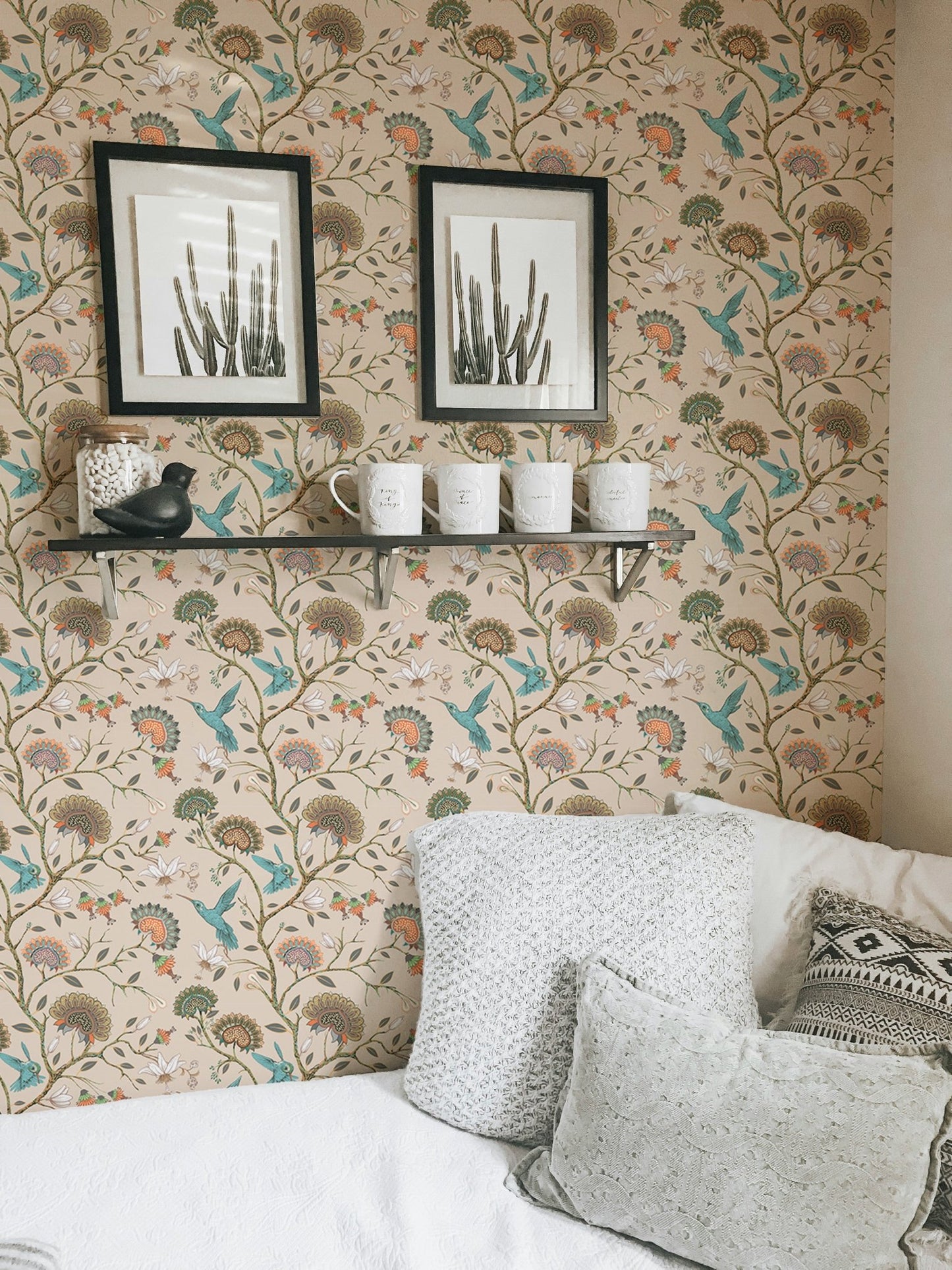 Floral wallpaper featuring hummingbirds on a living area wall with framed art.