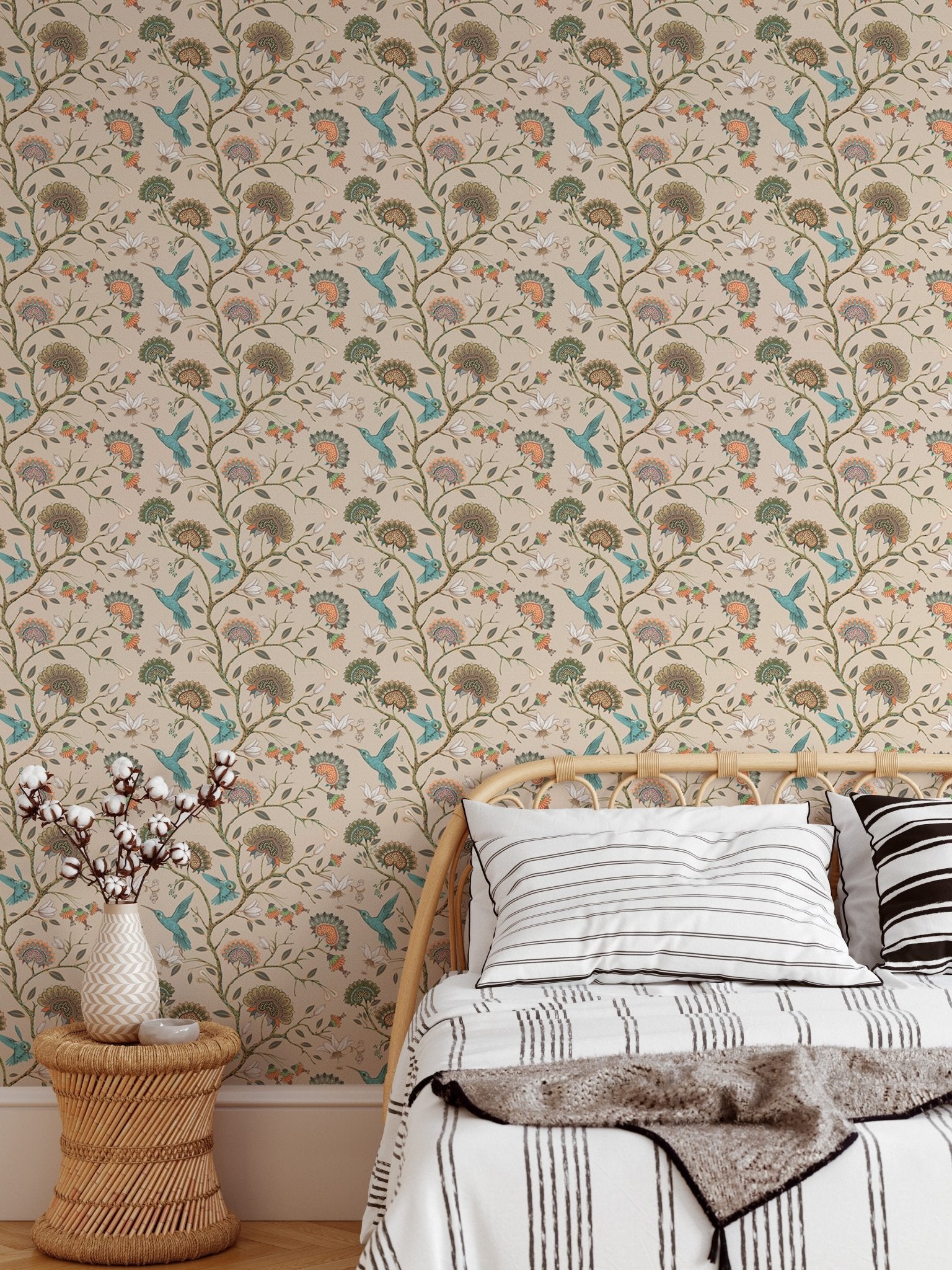 Hummingbird pattern wallpaper in a bedroom with a neutral bed and pillows.